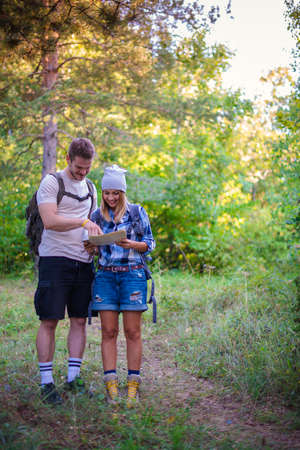 Young couple walking in the forest. Hiking concept in the mountain in summerの写真素材