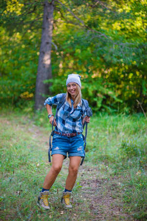 Young woman walking alone in the woods. Hiking concept in the mountain in summerの写真素材