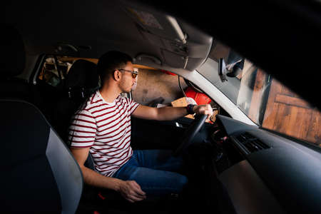 A guy carefully parking his car.の写真素材