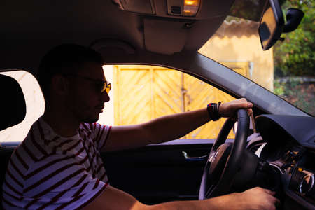 A guy carefully parking his car.の写真素材