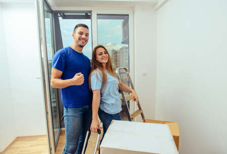 Cheerful couple embracing their new house while posingの写真素材