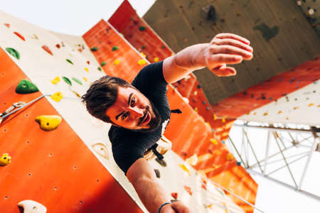 Free climber man descending down on bouldering wallの写真素材