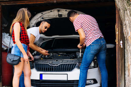 Girl waiting for the guy to check the oil so she could finally be on the road.の写真素材