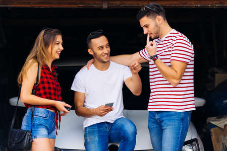 Three frineds poiniting fingers and talking about car facts.の写真素材