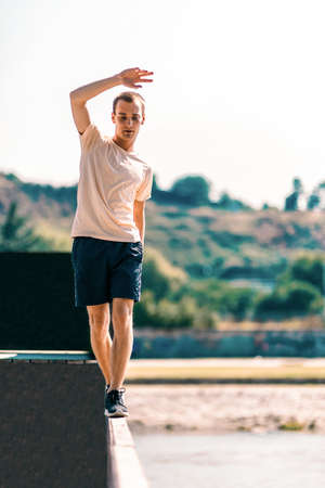 Handsome man training parkour while walking on the edgeの写真素材