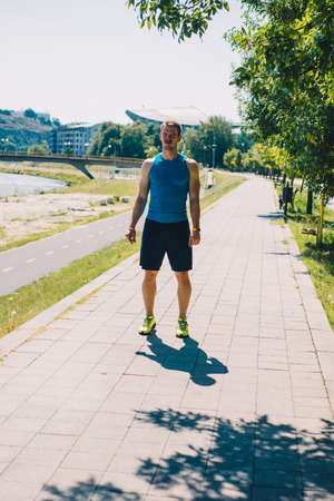 Sportive young man doing an outdoor jogging exercise at river sideの写真素材