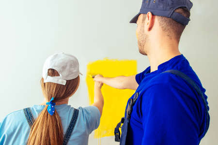 Happy couple painting walls in their new house ready for living togetherの写真素材