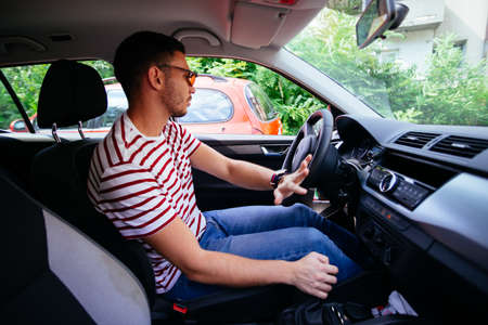 A guy carefully parking his car.の写真素材