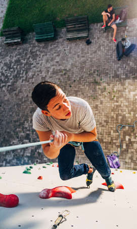 Sporty climber descending with the rope  of rock climbing artificial wallの写真素材