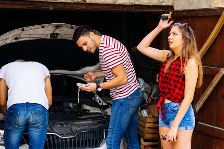 Girl waiting for the guy to check the oil so she could finally be on the road.