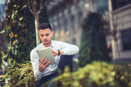 An urban guy is being nervous while holding and uses a tabletの写真素材