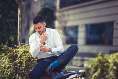 Stlyish businessman at urban place sitting on benc on sunny dayの写真素材