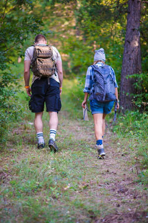 Young couple walking in the forest. Hiking concept in the mountain in summerの写真素材