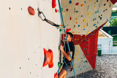 Young man climbing wall rock an extreme sportの写真素材