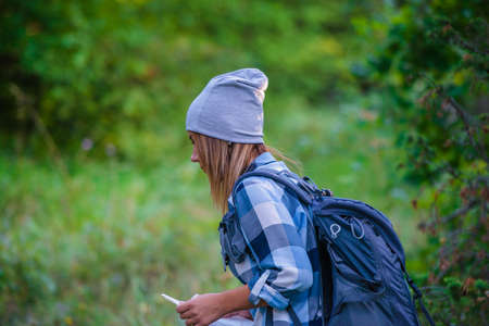 Young woman walking alone in the woods. Hiking concept in the mountain in summerの写真素材