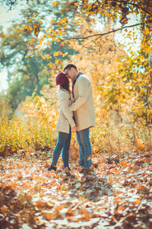 Loving couple is outdoors, cuddling and kissing in the park in autumnの写真素材