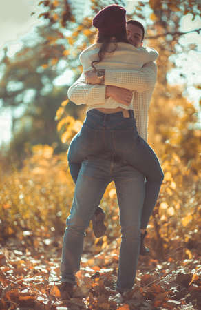 Cute couple is in the park in autumn, enjoying the day and looking happy togetherの写真素材