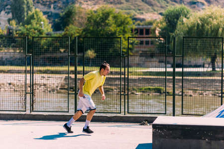 Training day of a young parkour man jumping over obstacles in skatepark