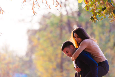 Beautiful girlfriend jumps on her boyfriends back to surprise him.の写真素材