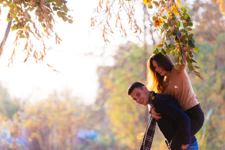 Beautiful girlfriend jumps on her boyfriends back to surprise him.の写真素材