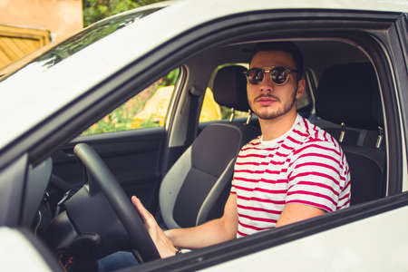 Man in his car in some neighborhood looking downの写真素材