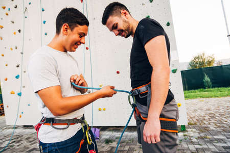 Young climbers alpinist prepare to rock-climbing on artificial boulderの写真素材