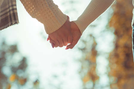 Modern couple is spending time together outdoors and holding hands on sunsetの写真素材