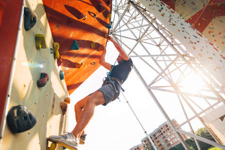 Young sporty man is bouldering in a climbing hallの写真素材