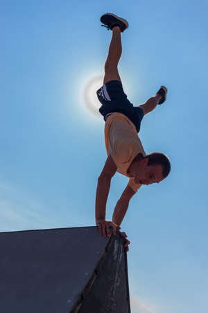 Parkour man training handstand while doing parkour in skateparkの写真素材