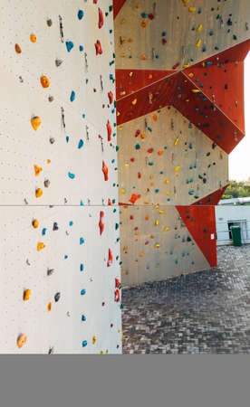 Artificial climbing wall covered with colored holds in an adventure playgroundの写真素材