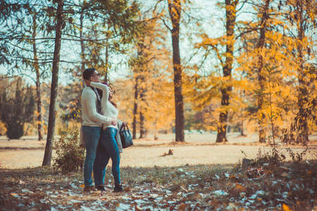 A guy and a girl are admiring the view of the wood while the girl hugs her boyfriendの写真素材