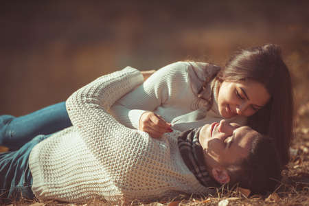 Charming couple is spending carefree time in the park, lying on the grass and restingの写真素材