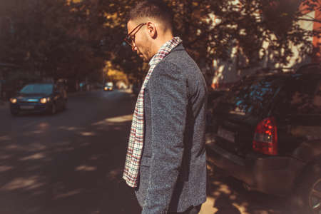 A stylish young man is being outdoors and exploring the city while looking seriousの写真素材