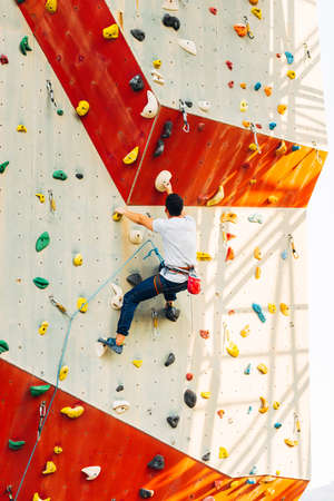 Handsome young man bouldering or rock climbing outdoorsの写真素材