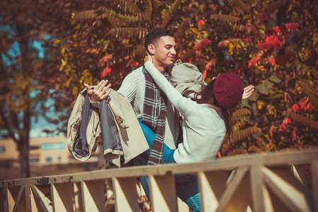 Magnificient couple is standing on a bridge in the park and fooling aroundの写真素材