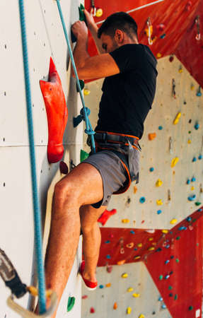 Young sporty man is bouldering in a climbing hallの写真素材