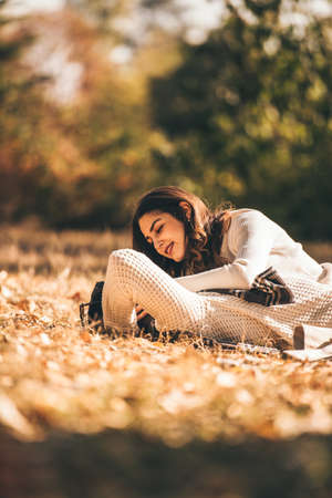 A beautiful young couple lying in the grass in a park in the sunsetの写真素材