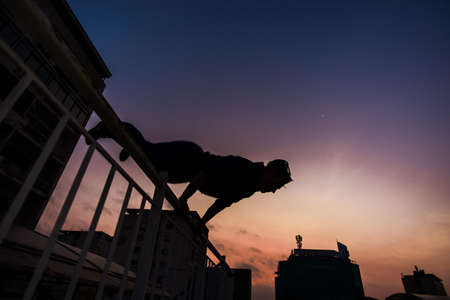 Sportive man doing handstand parkour outdoor
