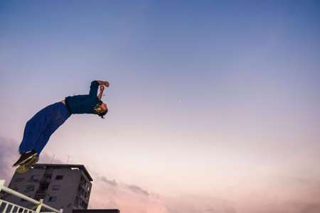 Man trains parkour while jumping in the air and doing tricksの写真素材