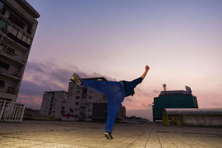 Courage guy doing parkour trick while jumping in air on the balconyの写真素材
