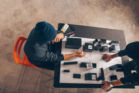 Men are sitting on the desk with a lot of maps and planing a heistの写真素材