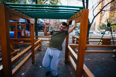 Young parkour guy doing tricks,flips and exercising at a playground.