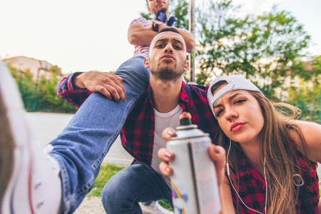 Three urban friends with spray color are having time together, looking serious