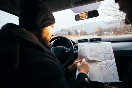 Two Robbers looking at a map and planning their next robbers,one of them is holding a gun.