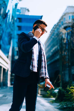 Young businessman speaking on mobile phone at the city financial center.の写真素材