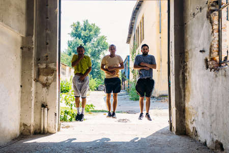 Three sporty friends in action while train together at abandoned factory
