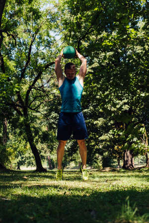 Man in sportswear exercising with medecine ball