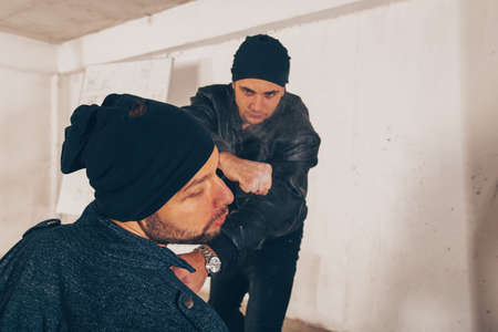 Aggressive man punching with fist during the fightの写真素材