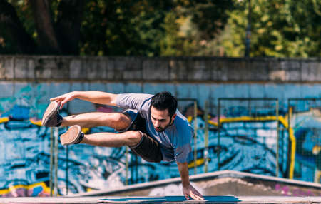 Parkour man in action while training at skatepark