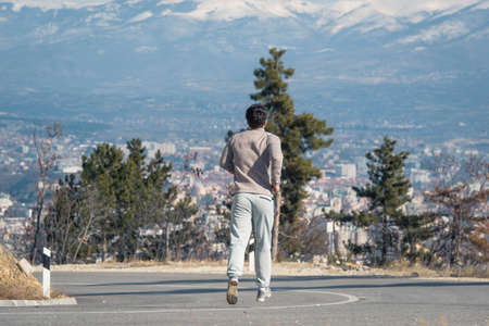Man is looking at the city panorama while jogging on a winter dayの写真素材